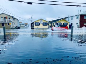 Car driving down flooded road