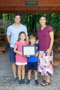 Rayann Dionne with her family (partner and two children holding award)