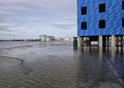 A house under construction that is on stilts is flooded underneath