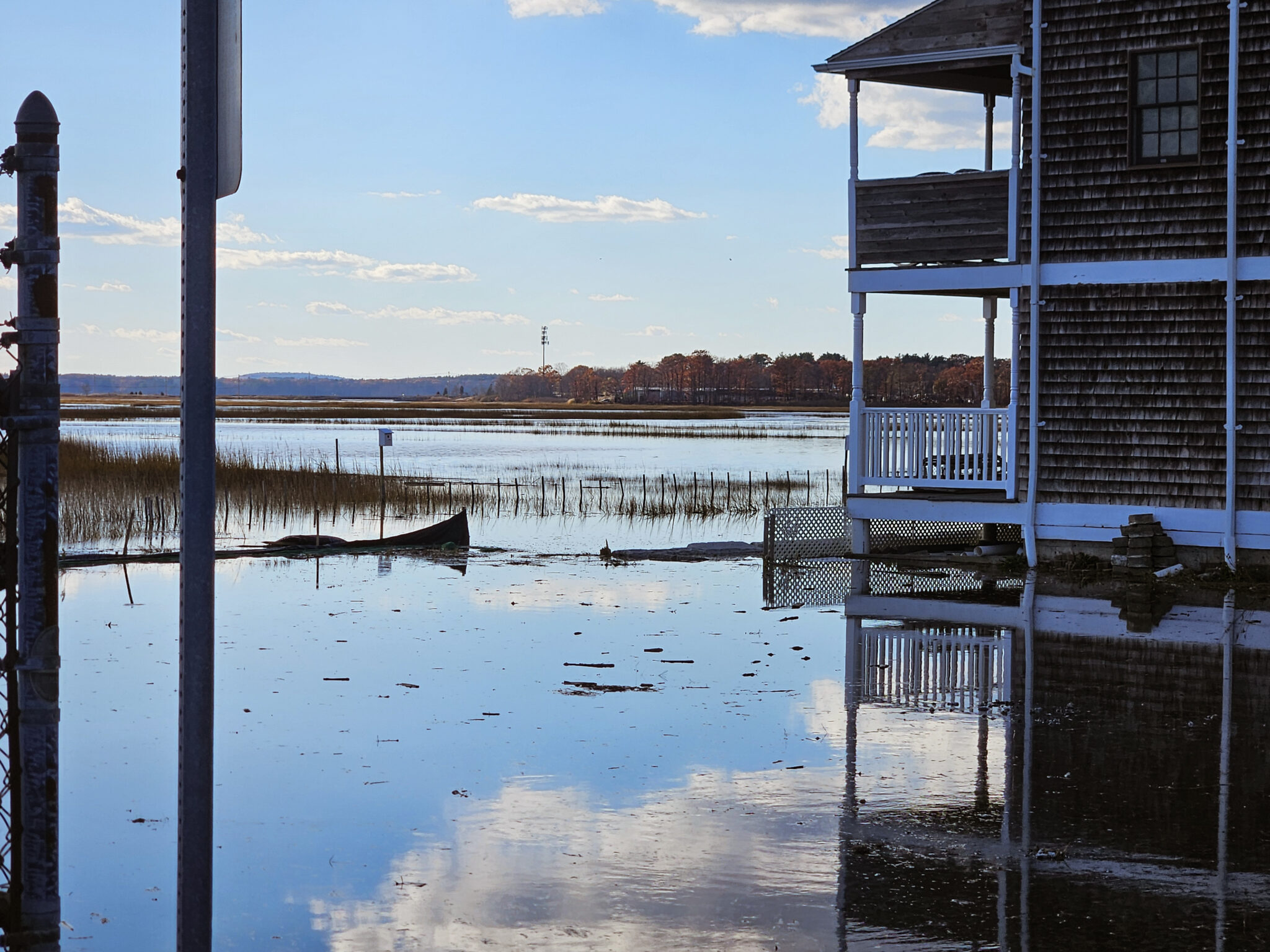 House and lawn flooded with reflection of blue sky in water
