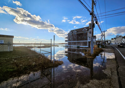Flooded neighborhood with blue sky reflected in water