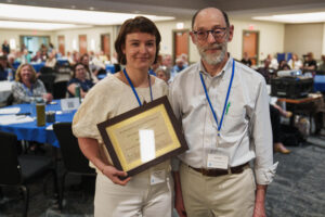 Brianna Hagan accepts community champion award from Jay Diener