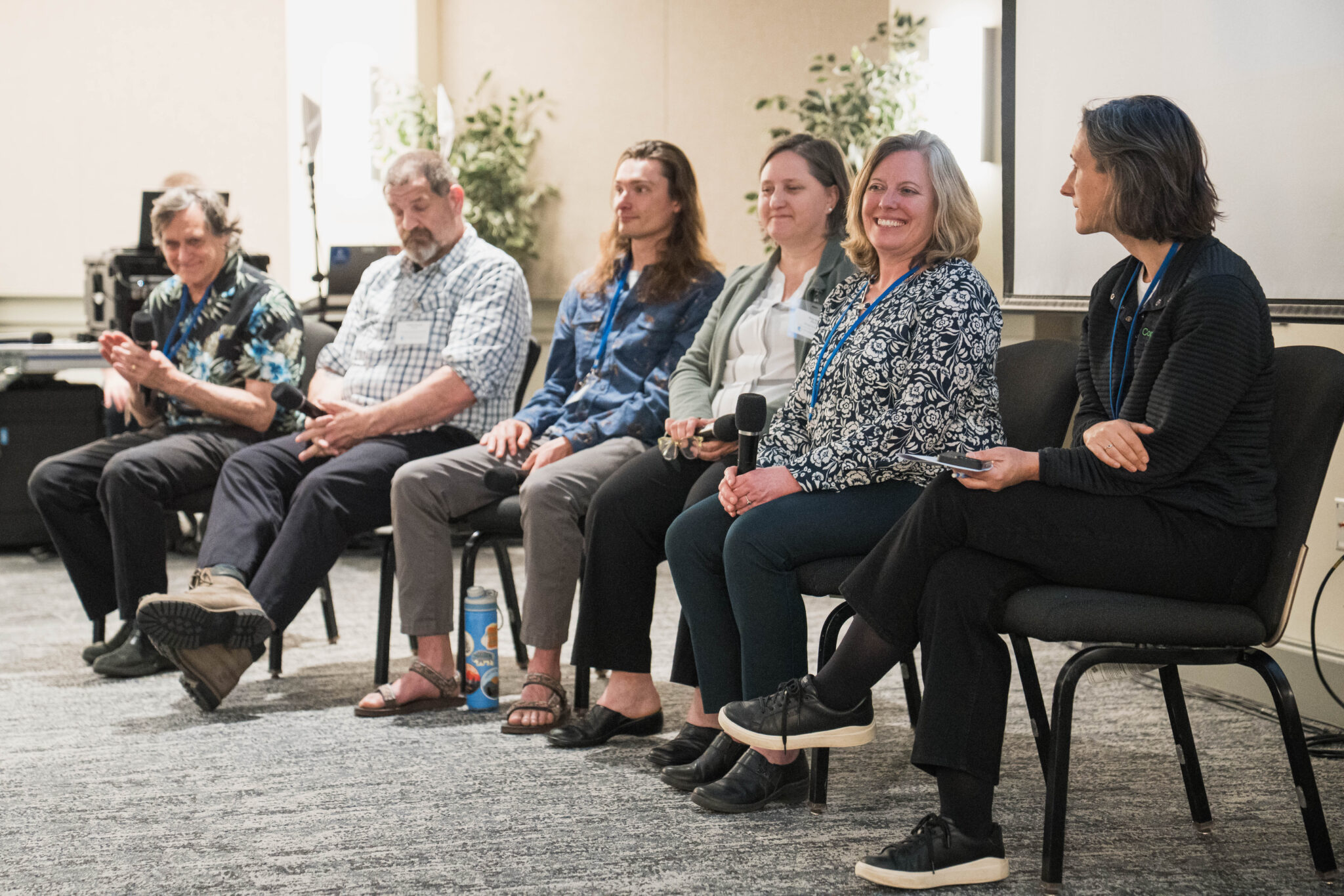 Six people sit in a row on a panel.