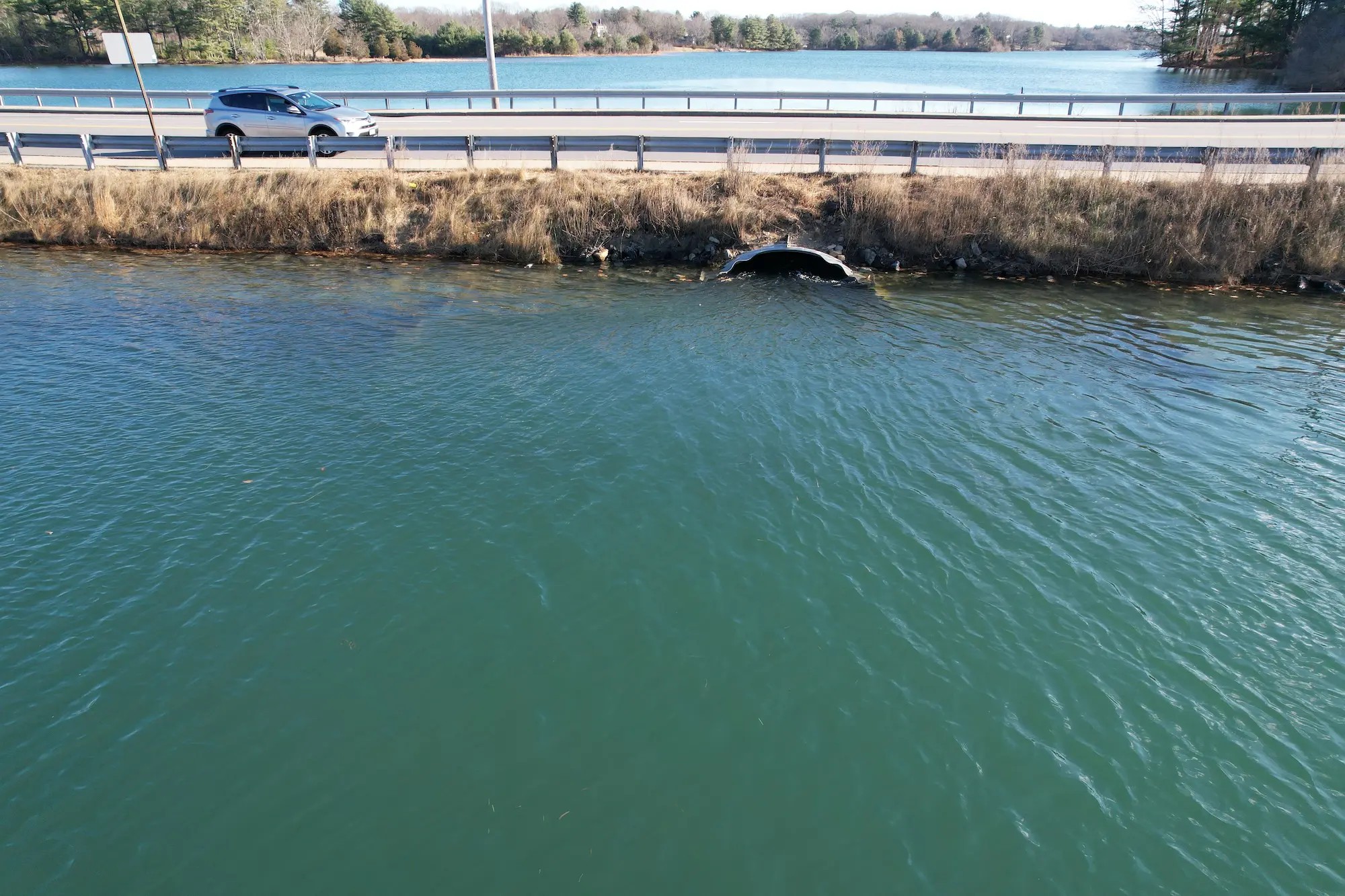 A culvert under a road is almost completely underwater.